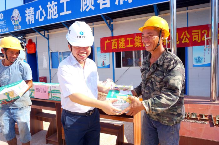 岑廷义为工人发放清冷慰问品。谢微旋 摄.jpg